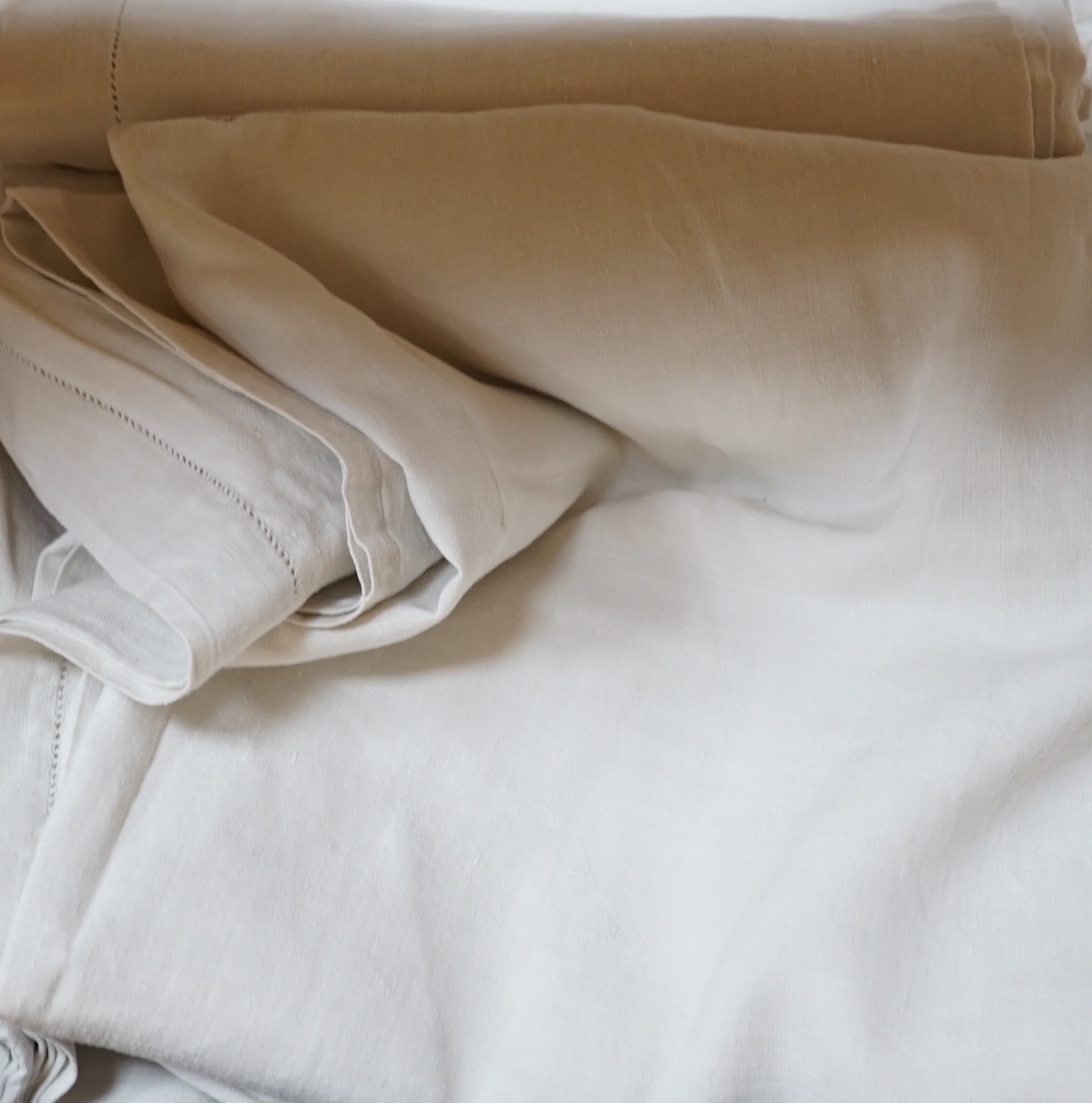 A quantity French provincial coarse linen sheets, seven with red cross stitched monogrammed turn backs, sheets approximately 6’ wide